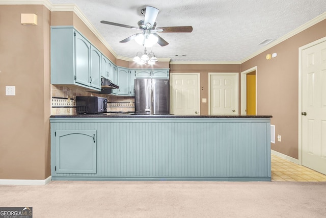 kitchen featuring decorative backsplash, blue cabinetry, stainless steel refrigerator, and light carpet