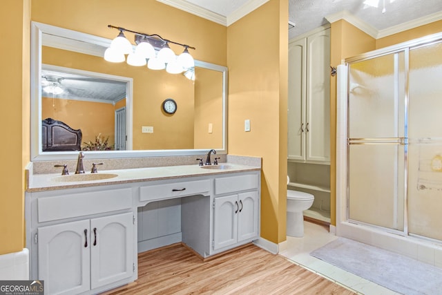 bathroom featuring a textured ceiling, vanity, hardwood / wood-style flooring, and ornamental molding