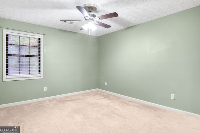 carpeted spare room featuring a textured ceiling and ceiling fan