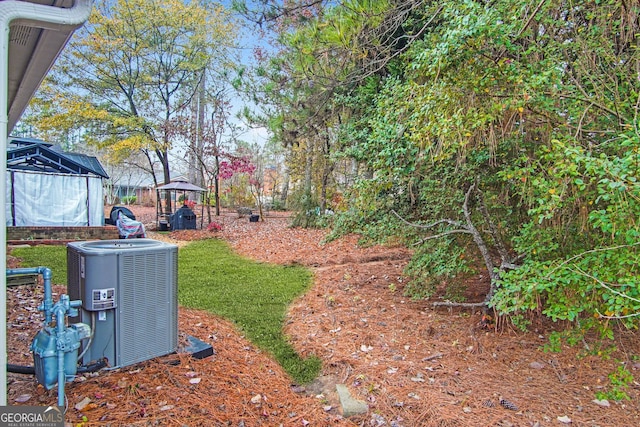 view of yard featuring a gazebo and central air condition unit