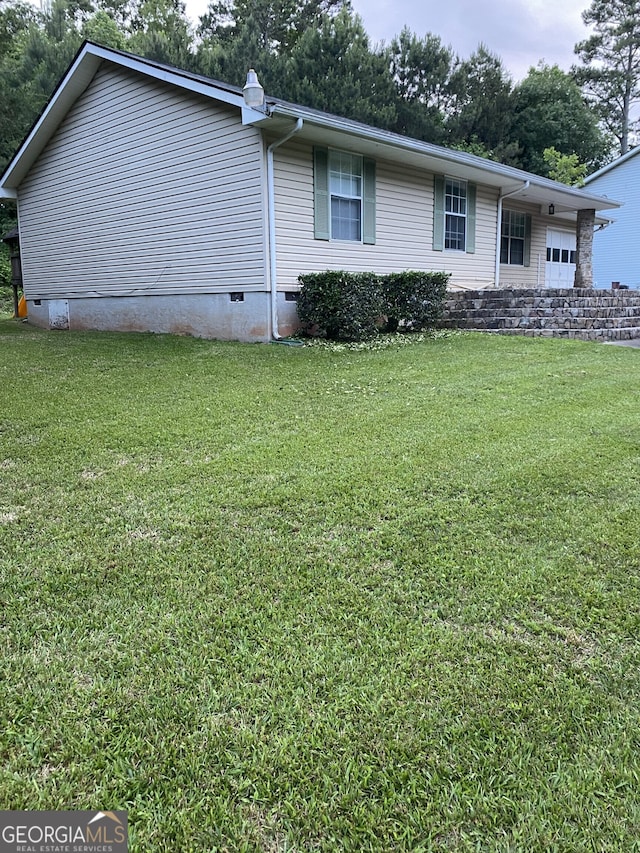 view of side of property featuring a yard and a garage