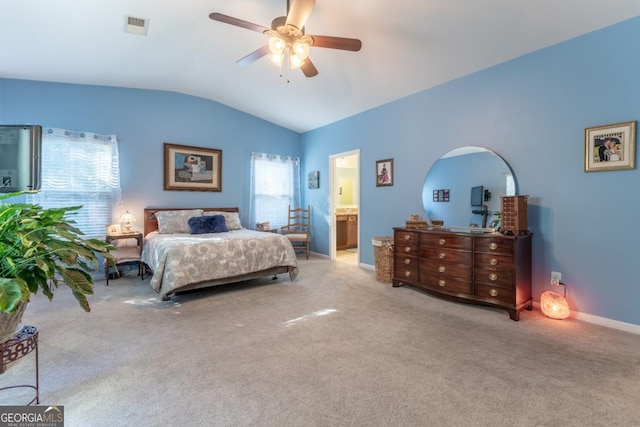 bedroom featuring vaulted ceiling, light colored carpet, ensuite bath, and ceiling fan