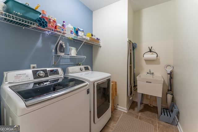 laundry area with washer and dryer and light tile patterned floors