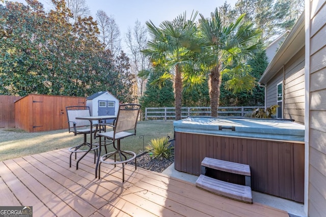 deck featuring a hot tub and a storage shed