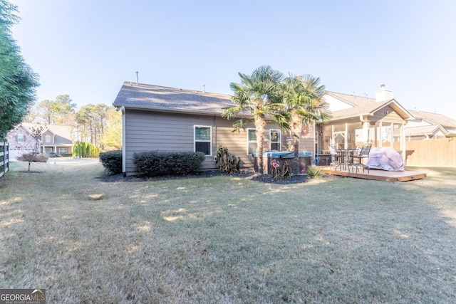 back of property with a yard and a wooden deck