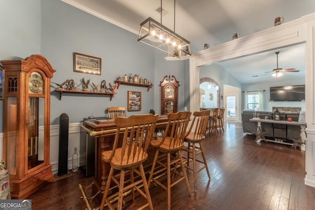 dining room featuring ceiling fan with notable chandelier, dark hardwood / wood-style flooring, and lofted ceiling