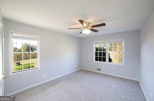 carpeted spare room featuring ceiling fan