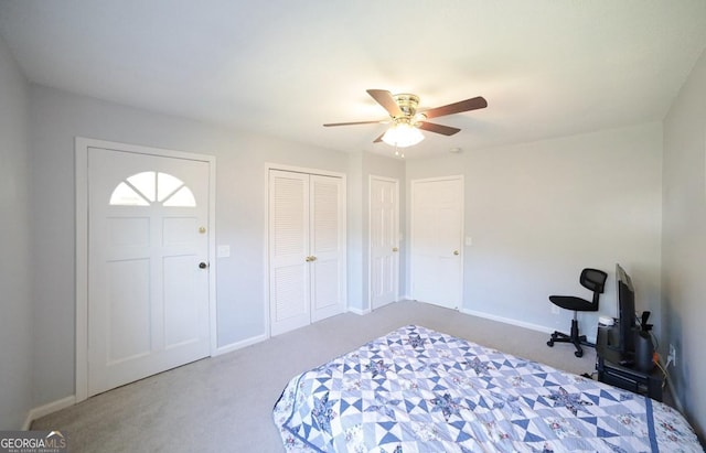 bedroom with multiple closets, ceiling fan, and carpet floors