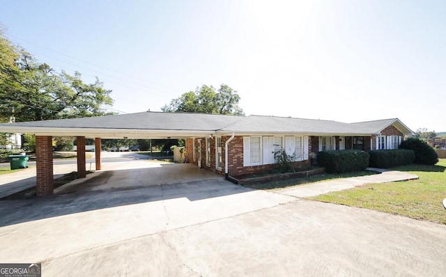 ranch-style house featuring a carport and a front lawn