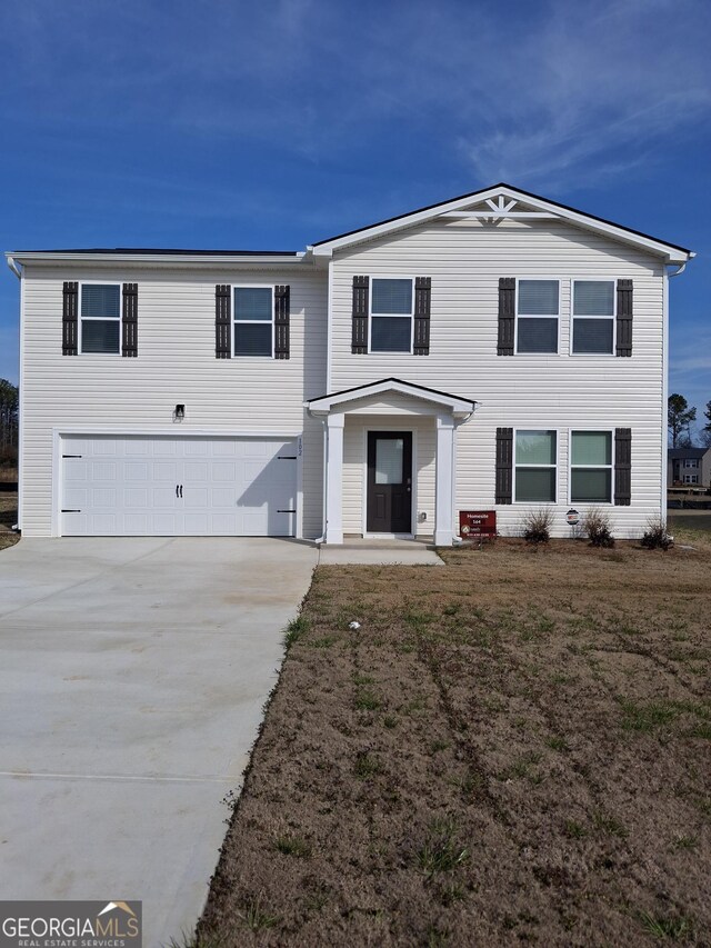 view of front of house featuring a front yard and a garage