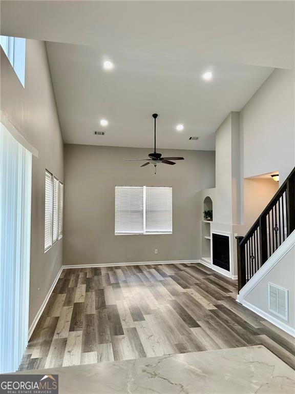 unfurnished living room with ceiling fan and hardwood / wood-style flooring