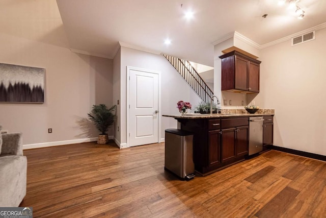 bar featuring dark brown cabinets, hardwood / wood-style flooring, ornamental molding, and sink