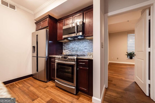 kitchen featuring backsplash, light hardwood / wood-style floors, crown molding, and stainless steel appliances