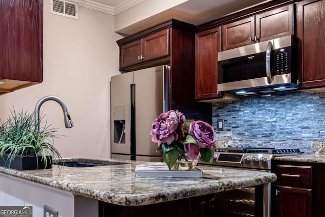 kitchen with decorative backsplash, light stone counters, stainless steel appliances, crown molding, and sink