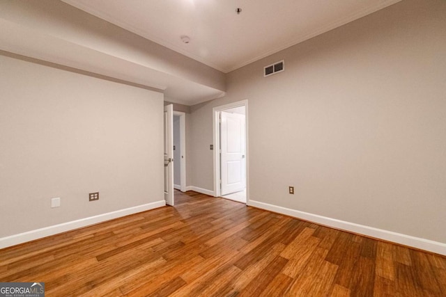 unfurnished room featuring ornamental molding and light hardwood / wood-style flooring