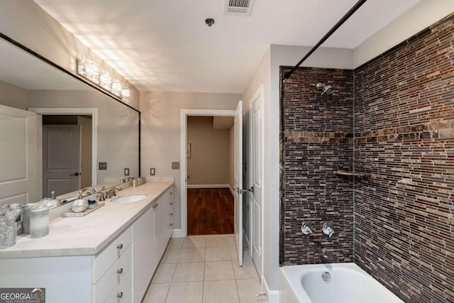 bathroom with tile patterned flooring, vanity, and tiled shower / bath