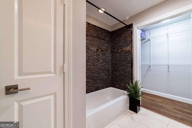 bathroom featuring wood-type flooring and tiled shower / bath