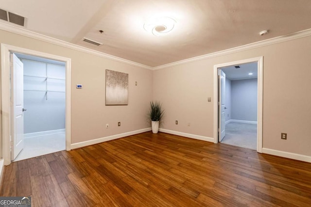 spare room with dark hardwood / wood-style floors and crown molding