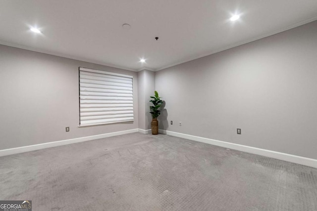 empty room featuring crown molding and carpet floors