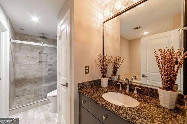 bathroom featuring vanity, toilet, and a shower with shower door