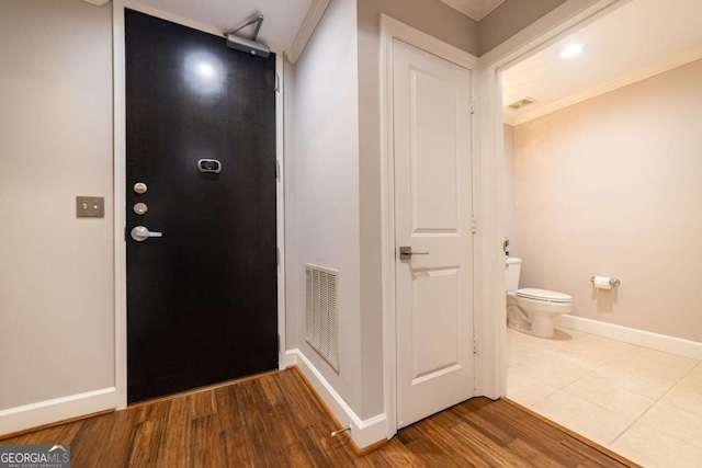 entrance foyer featuring hardwood / wood-style flooring and crown molding