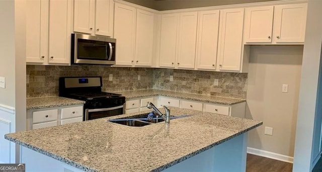 kitchen featuring tasteful backsplash, white cabinetry, sink, and stainless steel appliances