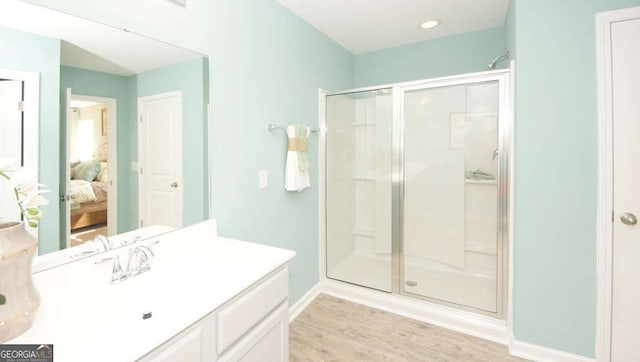 bathroom with vanity, hardwood / wood-style flooring, and a shower with shower door