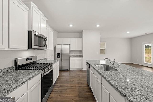 kitchen with light stone counters, sink, white cabinetry, and stainless steel appliances