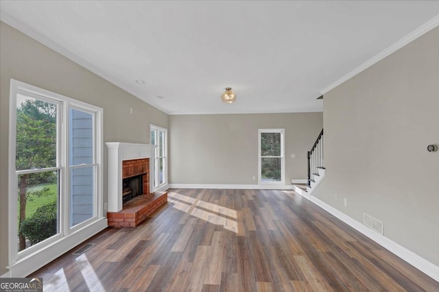 unfurnished living room featuring dark hardwood / wood-style floors, a brick fireplace, and ornamental molding