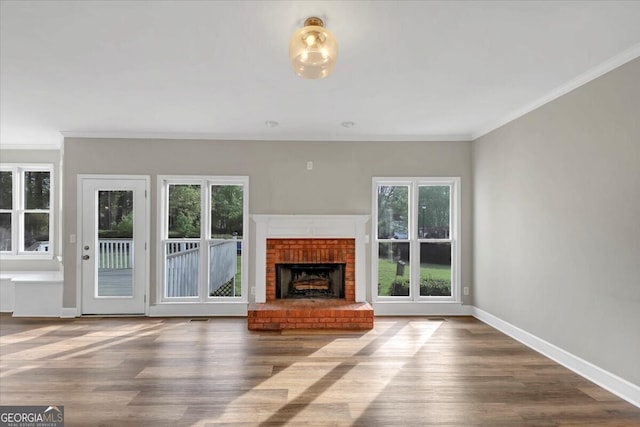 unfurnished living room featuring a wealth of natural light, crown molding, and wood-type flooring