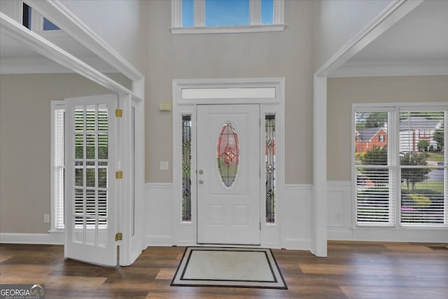 foyer entrance with dark hardwood / wood-style flooring and ornamental molding