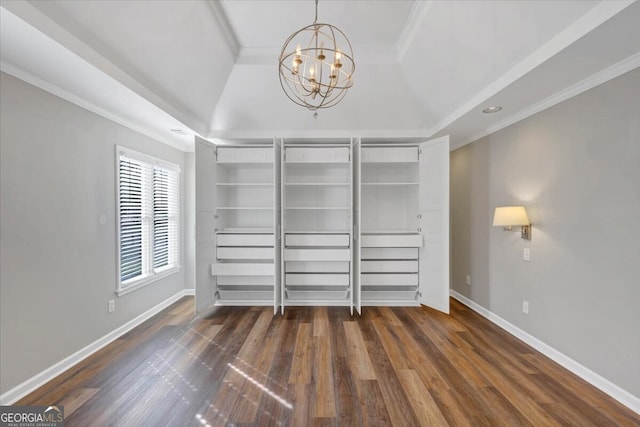 spacious closet featuring dark wood-type flooring and a notable chandelier