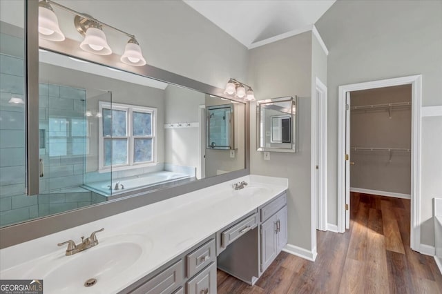 bathroom featuring vanity, independent shower and bath, vaulted ceiling, and hardwood / wood-style flooring