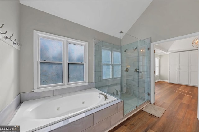 bathroom with hardwood / wood-style flooring, independent shower and bath, and lofted ceiling