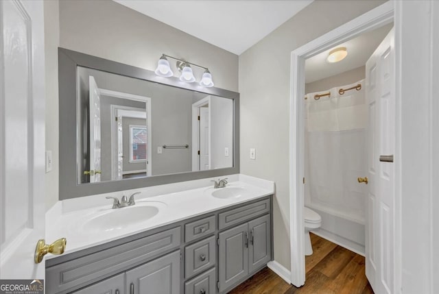 full bathroom featuring hardwood / wood-style floors, vanity, toilet, and shower / bath combo