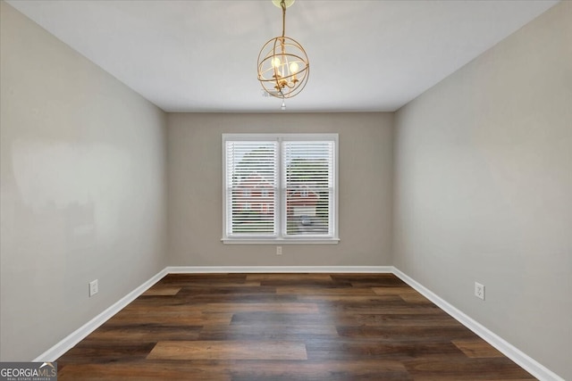 spare room featuring a notable chandelier and dark hardwood / wood-style flooring