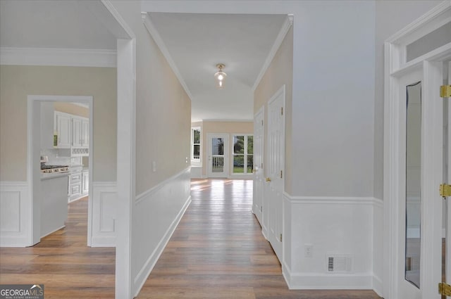 hallway featuring light hardwood / wood-style flooring and ornamental molding