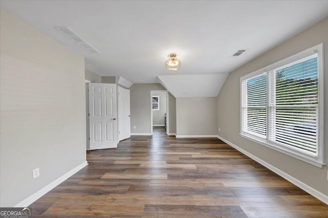 bonus room with dark wood-type flooring and vaulted ceiling