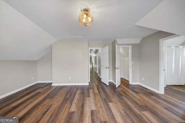 bonus room with dark hardwood / wood-style flooring and lofted ceiling