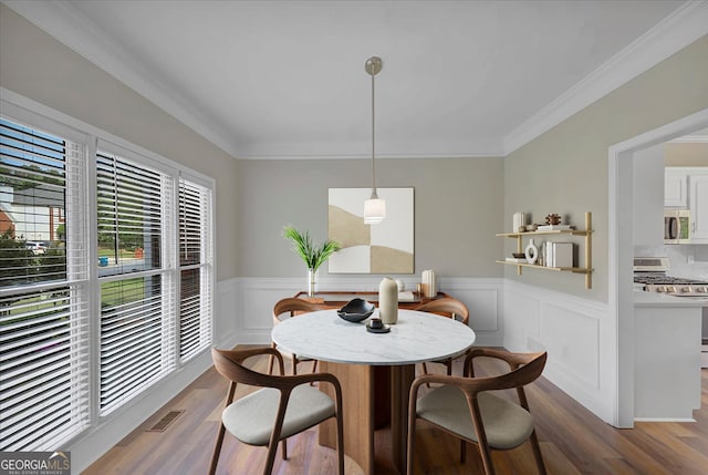 dining space featuring hardwood / wood-style floors and ornamental molding