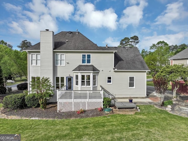 rear view of house featuring a yard and a deck