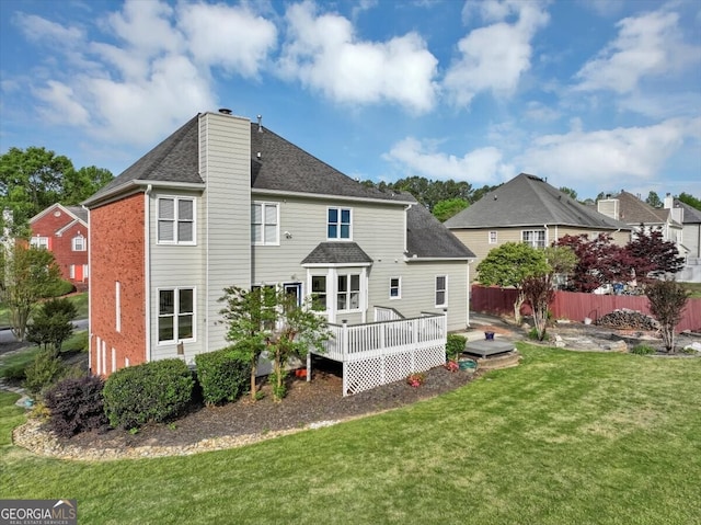 rear view of house featuring a yard and a deck