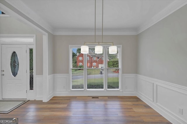 unfurnished dining area featuring crown molding and dark hardwood / wood-style floors