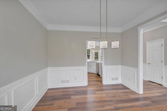 unfurnished dining area with dark wood-type flooring and ornamental molding