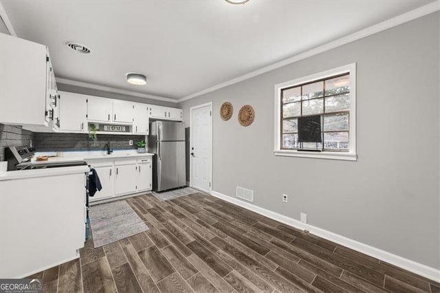 kitchen featuring decorative backsplash, stainless steel fridge, crown molding, dark wood-type flooring, and white cabinets