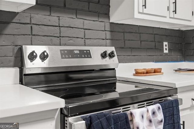 details with white cabinetry and stainless steel range with electric cooktop