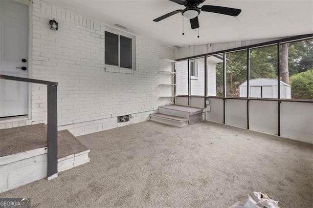 exterior space with carpet flooring, ceiling fan, brick wall, and vaulted ceiling