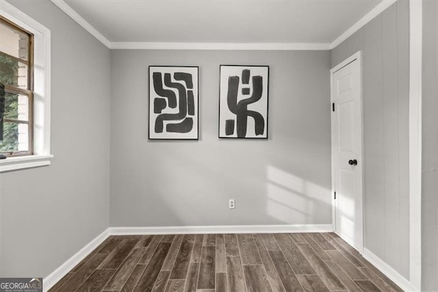 empty room with dark hardwood / wood-style flooring and ornamental molding