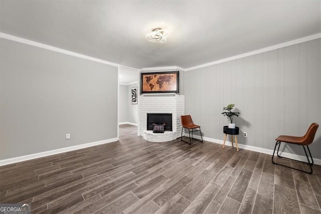 unfurnished room featuring crown molding, hardwood / wood-style floors, wood walls, and a brick fireplace