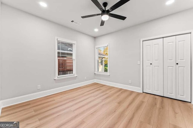 unfurnished bedroom featuring light wood-type flooring, a closet, and ceiling fan